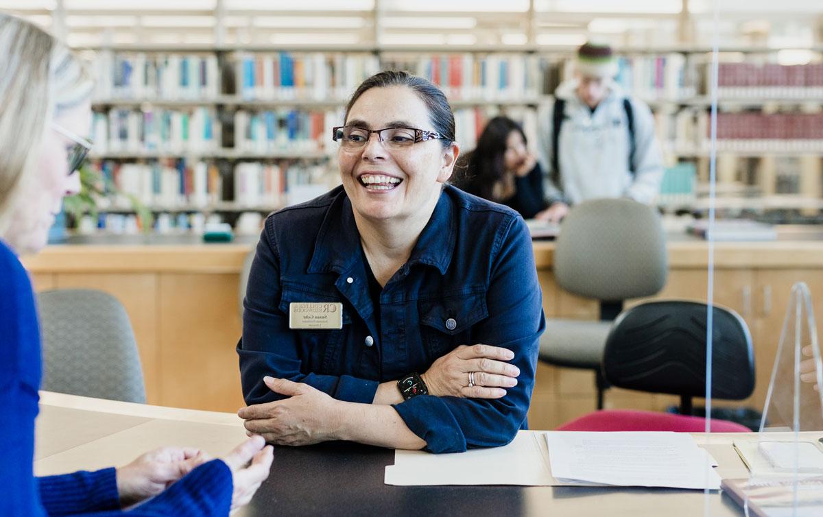 smiling librarian helping student